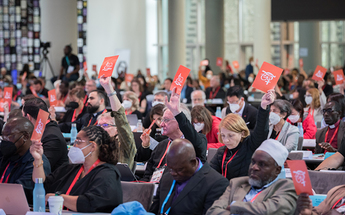 8 September 2022, Karlsruhe, Germany: Assembly participants raise orange consensus cards in affirmation of what is said during a closing business plenary at the 11th Assembly of the World Council of Churches, held in Karlsruhe, Germany from 31 August