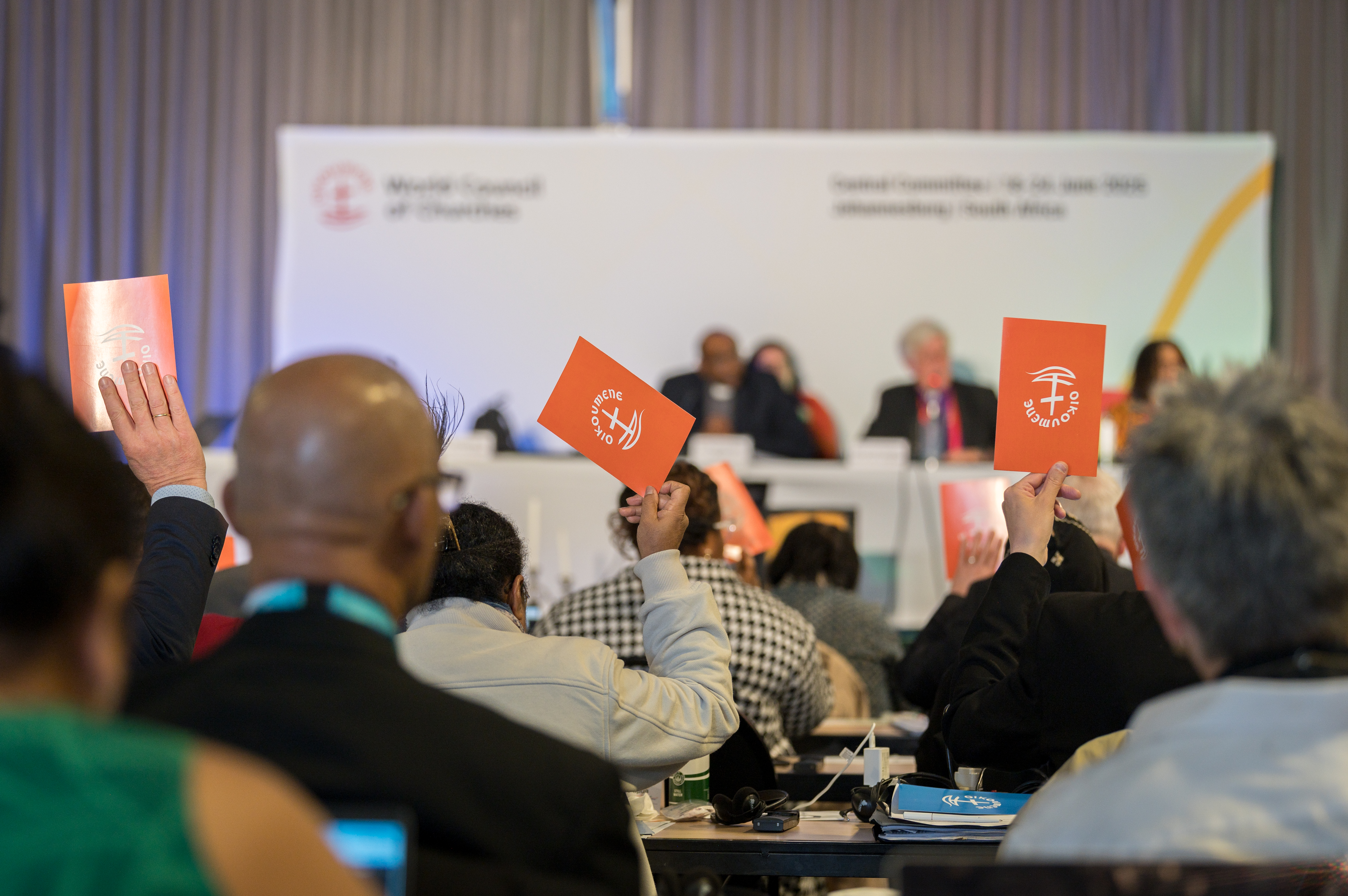 24 June 2025, Johannesburg, South Africa: Orange consensus cards are raised in affirmation of what has been proposed at the 2025 Central Committee meeting of the World Council of Churches taking place in Johannesburg (South Africa) from 18 to 24 June
