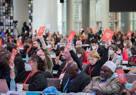 8 September 2022, Karlsruhe, Germany: Assembly participants raise orange consensus cards in affirmation of what is said during a closing business plenary at the 11th Assembly of the World Council of Churches, held in Karlsruhe, Germany from 31 August
